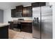 Modern kitchen features stainless steel appliances and dark wood cabinets with granite countertops at 1951 Betsy Ross Ln, St Cloud, FL 34769