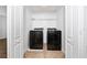 A laundry room with a modern washer and dryer, accessible between two white doors at 1951 Betsy Ross Ln, St Cloud, FL 34769