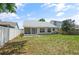 A spacious backyard features a well-maintained lawn, a screened patio, and a privacy fence at 10473 Glassborough Dr, Orlando, FL 32825