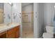 Bathroom with single sink vanity and walk-in shower, featuring tiled walls and grab bars at 10473 Glassborough Dr, Orlando, FL 32825
