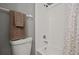 Bathroom featuring a toilet, and a shower/tub with a white tiled walls and shower curtain at 10473 Glassborough Dr, Orlando, FL 32825