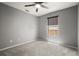 Grey carpeted bedroom features a ceiling fan and a large window for natural light at 10473 Glassborough Dr, Orlando, FL 32825