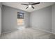 Grey carpeted bedroom featuring a window and ceiling fan at 10473 Glassborough Dr, Orlando, FL 32825
