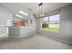 Dining area with a modern light fixture, open to the kitchen, and a large window overlooking the backyard at 10473 Glassborough Dr, Orlando, FL 32825