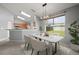 Sunlit dining area featuring a modern light fixture, marble table, and views of the backyard at 10473 Glassborough Dr, Orlando, FL 32825