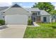 Charming home featuring a two-car garage, well-manicured lawn, and inviting entryway at 10473 Glassborough Dr, Orlando, FL 32825