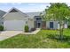 Charming single-Gathering home with an attached garage, front lawn, and beautiful landscaping at 10473 Glassborough Dr, Orlando, FL 32825