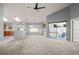 Open living room with vaulted ceilings, large windows, access to the screened lanai, and a ceiling fan at 10473 Glassborough Dr, Orlando, FL 32825
