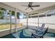 Screened-in porch featuring a ceiling fan, two chairs, and an area rug at 10473 Glassborough Dr, Orlando, FL 32825