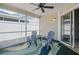 Enclosed porch features two chairs, an area rug, a ceiling fan, and a sliding glass door at 10473 Glassborough Dr, Orlando, FL 32825