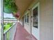 Exterior walkway featuring building facade with decorative potted flowers and well maintained landscape at 1100 E Caroline St # 204, Tavares, FL 32778
