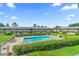 Aesthetic community pool surrounded by lush greenery and various building structures at 1100 E Caroline St # 204, Tavares, FL 32778