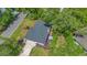 Aerial view showcases the home's roof, large deck, landscaped yard, and the surrounding greenery at 1200 Ridge Rd, Longwood, FL 32750