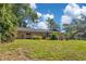 Well-maintained single Gathering house featuring attractive lawn and lush, mature trees on a sunny day at 1200 Ridge Rd, Longwood, FL 32750