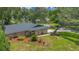 Home exterior with stone accents, beautiful landscaping, and a mature tree with a swing at 1200 Ridge Rd, Longwood, FL 32750