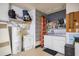A functional laundry room with washer, dryer, utility sink, and ample shelving for storage at 1200 Ridge Rd, Longwood, FL 32750