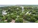 Panoramic aerial view of a charming community with lush greenery, a water tower, and homes near the water's edge at 121 W Oakland Ave, Oakland, FL 34760