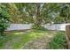 Spacious backyard featuring mature trees, partial fence and green space at 121 W Oakland Ave, Oakland, FL 34760