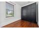 Cozy bedroom featuring hardwood floors and a window with outside views at 121 W Oakland Ave, Oakland, FL 34760