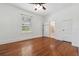 Spacious bedroom featuring hardwood floors, a ceiling fan, and natural light at 121 W Oakland Ave, Oakland, FL 34760