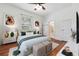 Bright bedroom with hardwood floors, neutral decor, and an en suite bathroom at 121 W Oakland Ave, Oakland, FL 34760