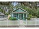 Charming blue cottage-style home with a white picket fence and mature landscaping at 121 W Oakland Ave, Oakland, FL 34760