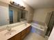 Bathroom with double sinks, a large mirror, and a separate shower and tub at 1227 Juniper Hammock St, Winter Garden, FL 34787