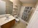 This bathroom features a vanity with sink, toilet, and a shower/tub with a patterned curtain at 1227 Juniper Hammock St, Winter Garden, FL 34787