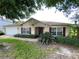 Charming single-story home featuring manicured landscaping, brown shutters, and a brick-paved walkway at 1227 Juniper Hammock St, Winter Garden, FL 34787
