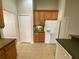 Functional kitchen with wood cabinets and white refrigerator, adjacent to pantry at 1227 Juniper Hammock St, Winter Garden, FL 34787