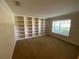 Living room with built in shelving and natural light from the window at 1227 Juniper Hammock St, Winter Garden, FL 34787
