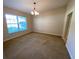 Spacious carpeted living room with large window, chandelier, and neutral walls at 1227 Juniper Hammock St, Winter Garden, FL 34787