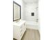 Bright bathroom featuring a tub with marble tile surround, vanity, and modern fixtures at 1309 Hillsborough Ln, Kissimmee, FL 34759