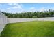 Large backyard enclosed by a white privacy fence and green lawn at 1351 Fox Squirrel Dr, Davenport, FL 33897