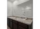 Bathroom with dual sinks, granite counters, and a large mirror over the vanity at 1351 Fox Squirrel Dr, Davenport, FL 33897