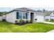 Charming single-story home with lush lawn, dark mulch landscaping, and a two-car garage at 1351 Fox Squirrel Dr, Davenport, FL 33897