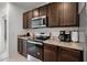 Stylish kitchen features dark cabinets, granite countertops, and stainless steel appliances at 1351 Fox Squirrel Dr, Davenport, FL 33897