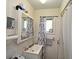 Bathroom with small vanity and tiled shower with curtain at 1390 E Airport Blvd, Sanford, FL 32773
