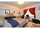 Cozy bedroom with neutral walls, dark wood furnishings, and red curtains at 1390 E Airport Blvd, Sanford, FL 32773
