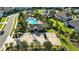 Aerial view of a community clubhouse, pool, parking lot, playground, and surrounding greenery at 13924 Jomatt Loop, Winter Garden, FL 34787