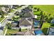Aerial view of a two-story home with a screened-in pool, solar panels, and a well-manicured lawn at 13924 Jomatt Loop, Winter Garden, FL 34787