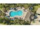 Top-down aerial view of a community pool, cabana, surrounding chairs, and lush tropical landscaping at 13924 Jomatt Loop, Winter Garden, FL 34787