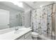 Neutral bathroom featuring a single sink vanity with a large mirror and a shower with a Paris-themed curtain at 13924 Jomatt Loop, Winter Garden, FL 34787