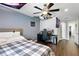 This bedroom features wood floors, a ceiling fan and unique lights, and is adjacent to a hallway at 13924 Jomatt Loop, Winter Garden, FL 34787