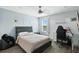 This bedroom features wood floors, a ceiling fan and a unique decorative wall for the perfect gamer aesthetic at 13924 Jomatt Loop, Winter Garden, FL 34787