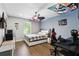 This bedroom features wood floors, a ceiling fan and unique lights and decor, perfect for any gamer at 13924 Jomatt Loop, Winter Garden, FL 34787