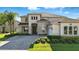 Charming two-story home with stone accents, manicured landscaping, and a welcoming entrance at 13924 Jomatt Loop, Winter Garden, FL 34787