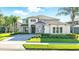 Elegant two-story home boasts a stone facade, manicured landscaping, and a paver driveway at 13924 Jomatt Loop, Winter Garden, FL 34787