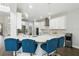 Bright kitchen features a large center island with quartz counters and stylish blue chairs at 13924 Jomatt Loop, Winter Garden, FL 34787