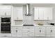 Modern kitchen with stainless steel appliances, white cabinetry, and a sleek range hood at 13924 Jomatt Loop, Winter Garden, FL 34787